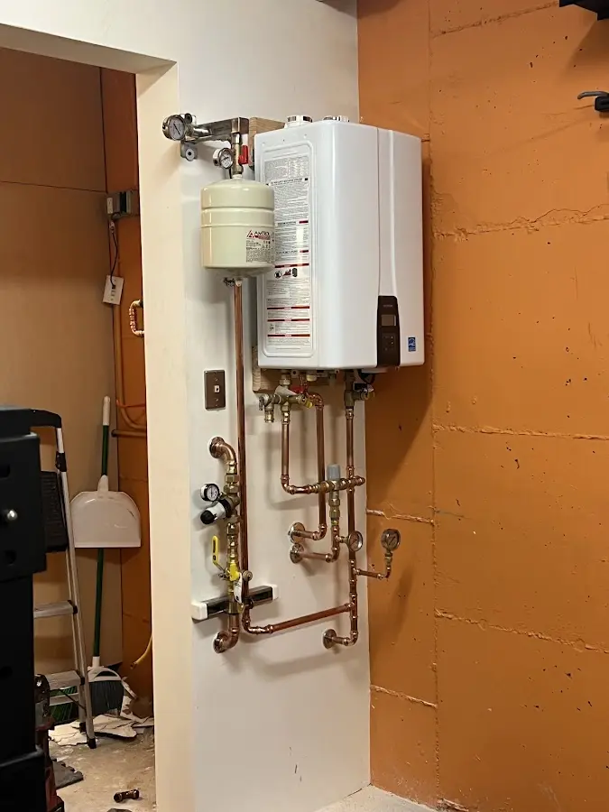 Plumbing technician inspecting water heater connections in Lindale